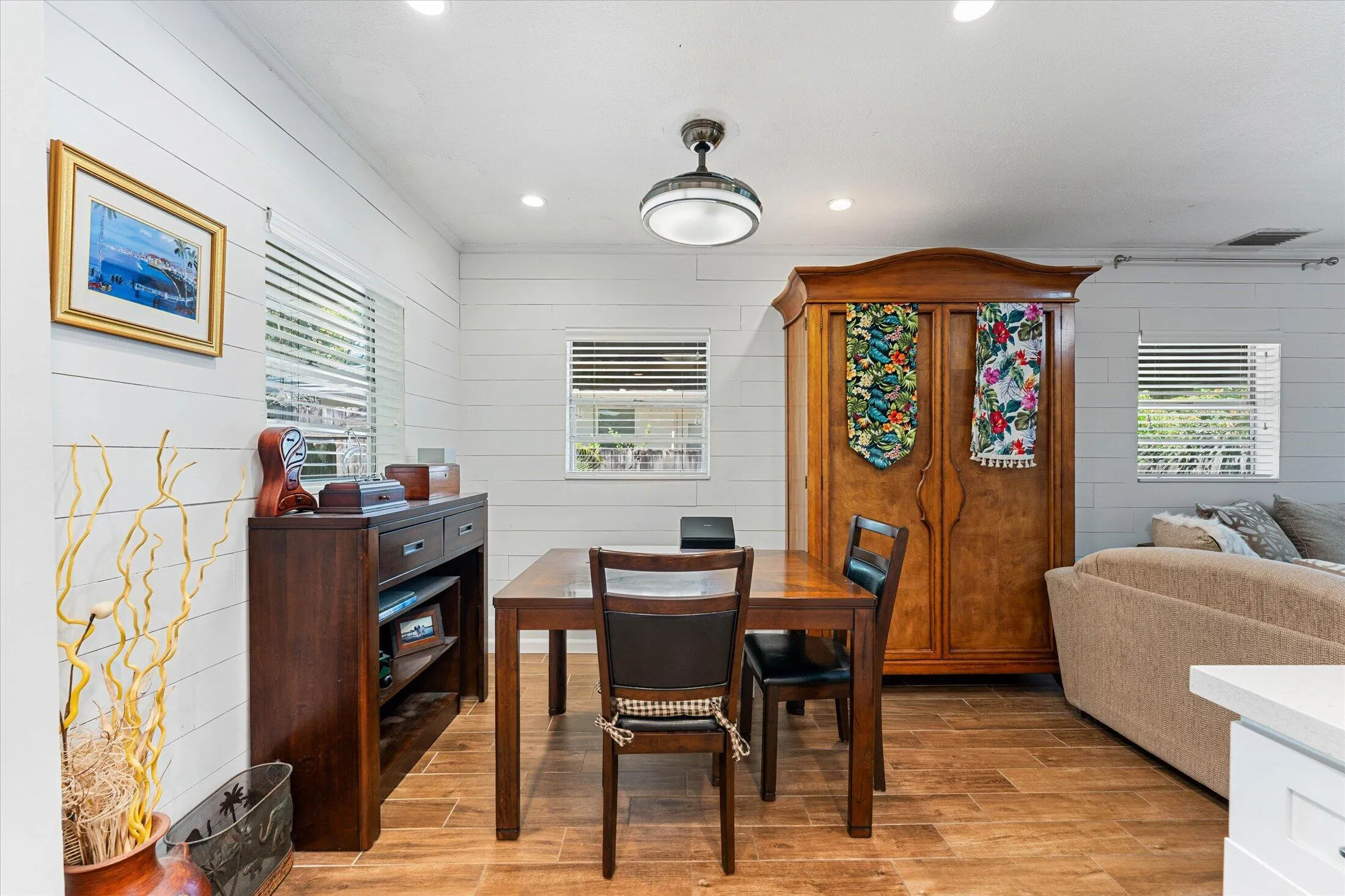 Dining area featuring wood-finish flooring, white shiplap walls, recessed lighting, and a ceiling-mounted light fixture