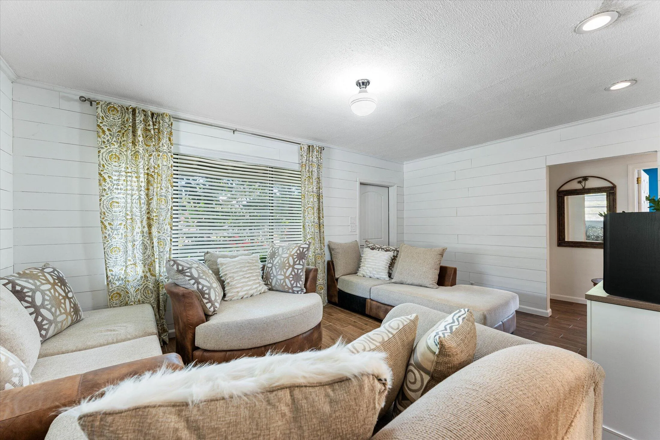 Living area featuring shiplap walls, recessed lighting, and wood-finish flooring