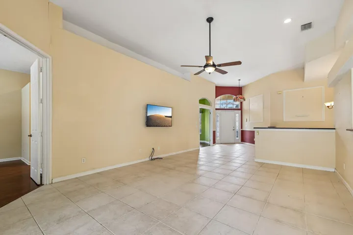 Spacious interior featuring neutral-toned walls, tile flooring, and a ceiling fan