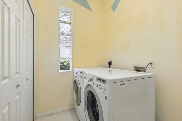 Laundry area featuring a vertical glass block window and bi-fold closet doors