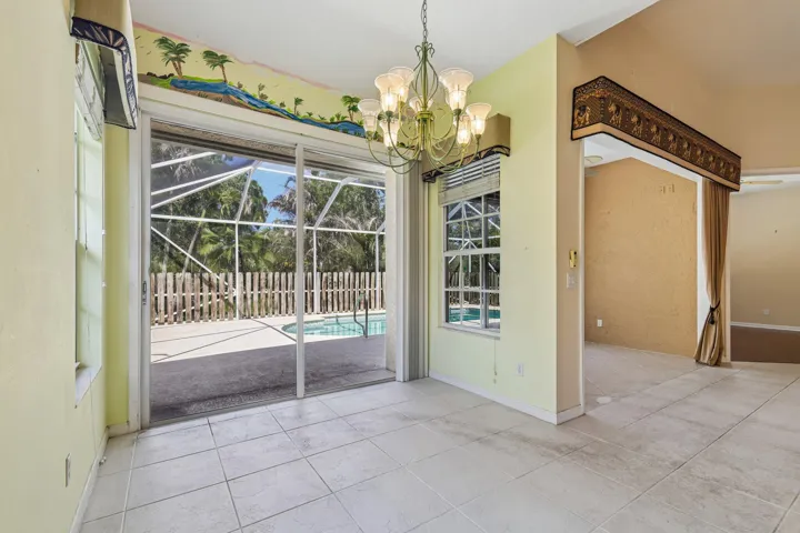 Sliding glass doors opening to a screened pool area with a privacy fence
