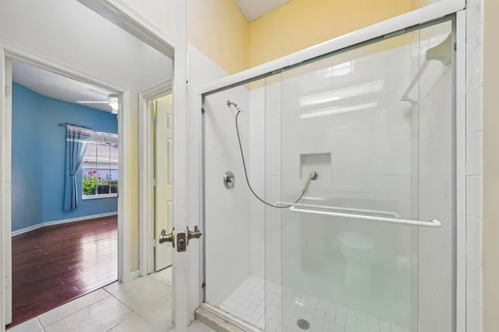 Glass-enclosed shower with white subway tile surround, integrated shower niche, and handheld shower fixture