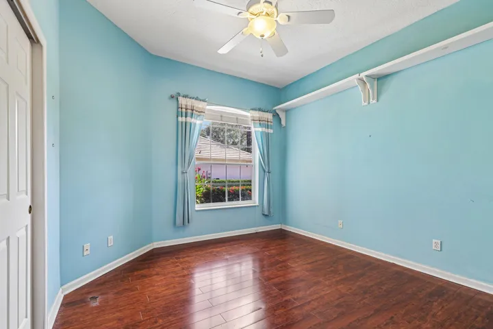 Room featuring rich wood-finish flooring and a ceiling fan with integrated lighting