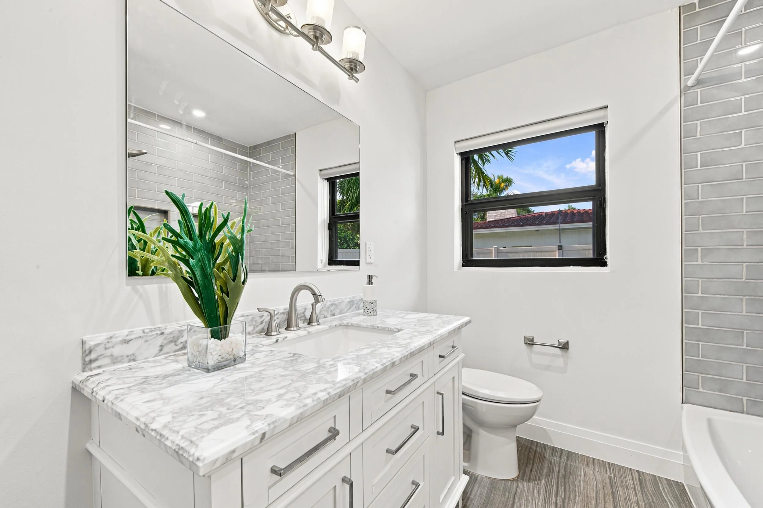 Bathroom featuring a white vanity with a stone countertop, an undermount sink, and brushed nickel fixtures