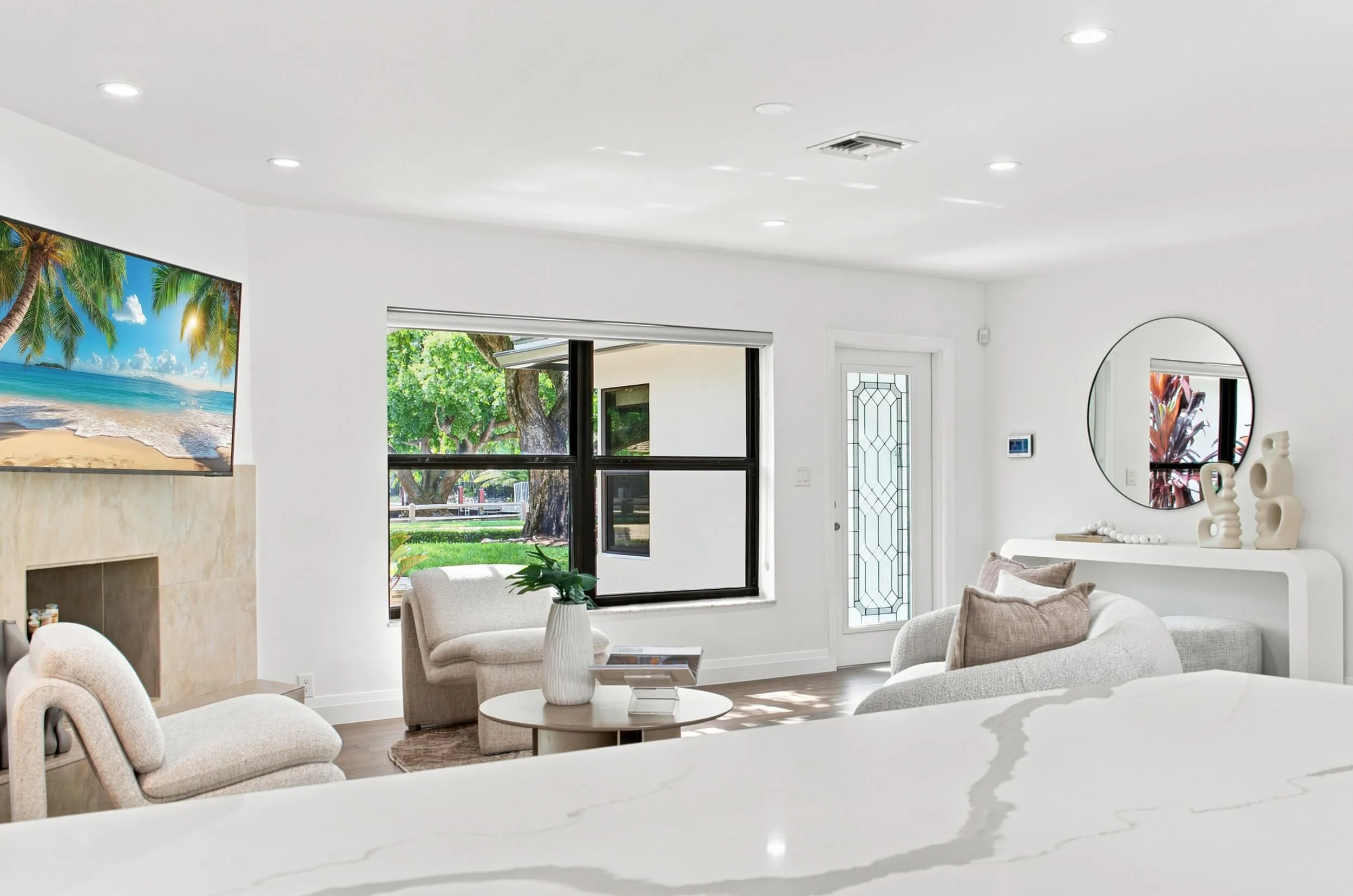 Living area featuring recessed lighting, a stone-clad fireplace, and large windows with outdoor views