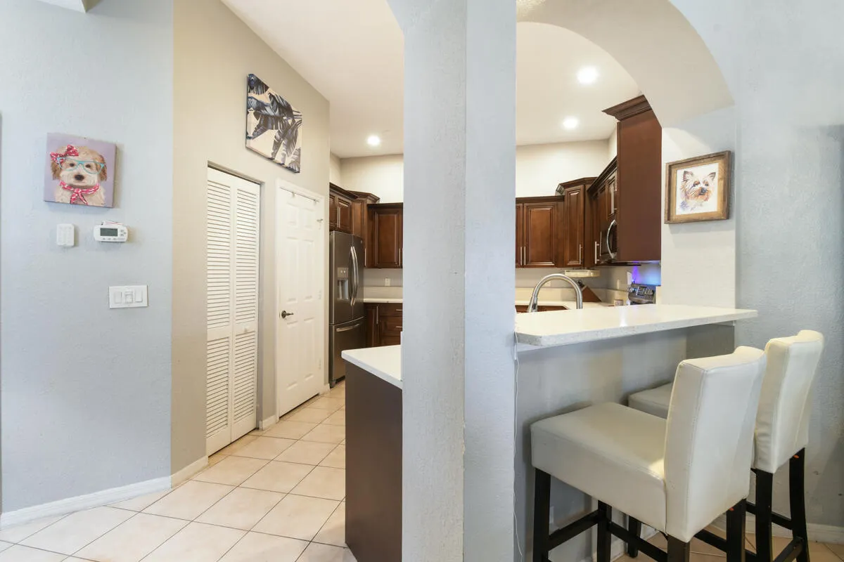 Kitchen featuring an arched pass-through to a breakfast bar with a light-toned countertop