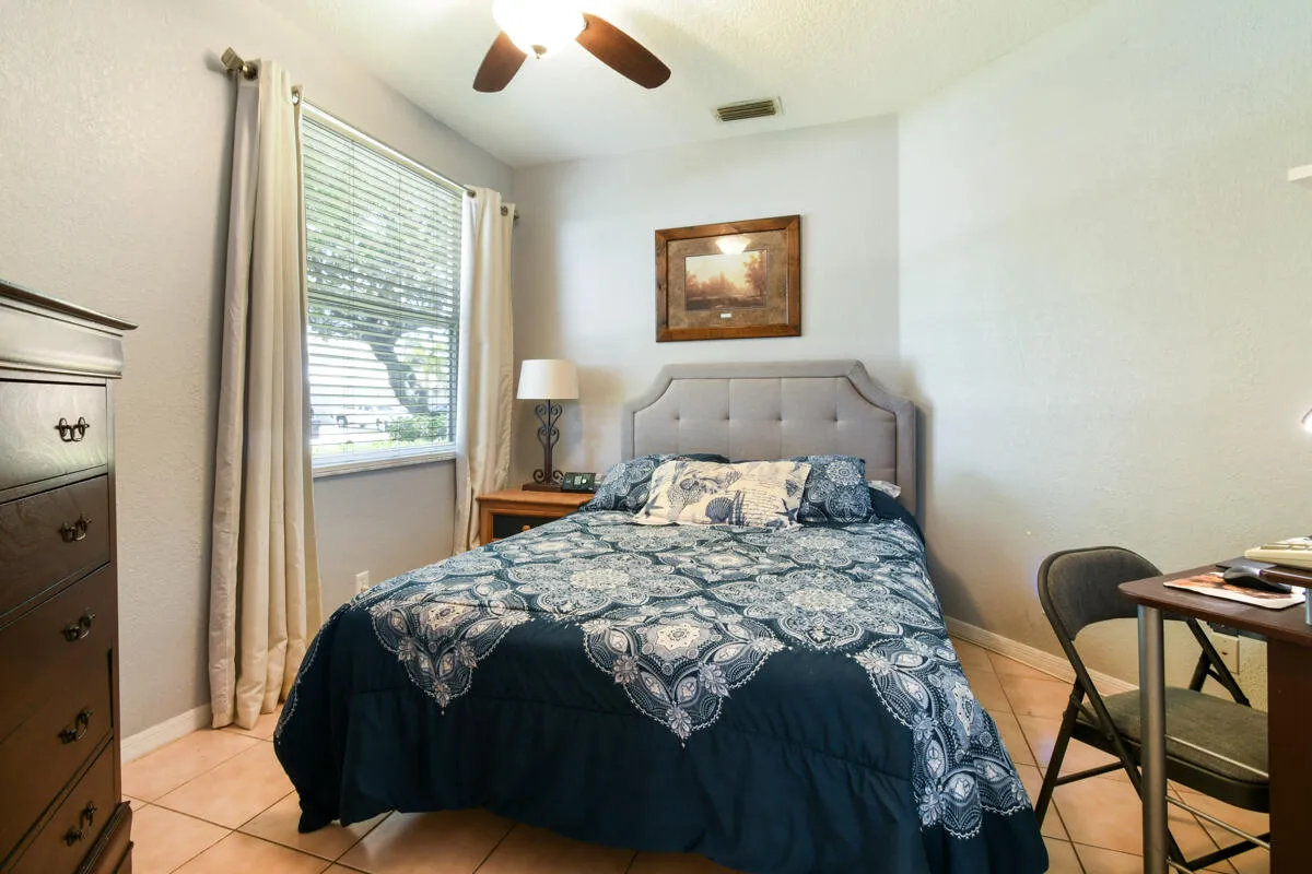 Bedroom featuring tile flooring and a ceiling fan with integrated lighting