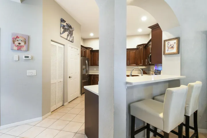 Kitchen featuring an arched pass-through to a breakfast bar with a light-toned countertop