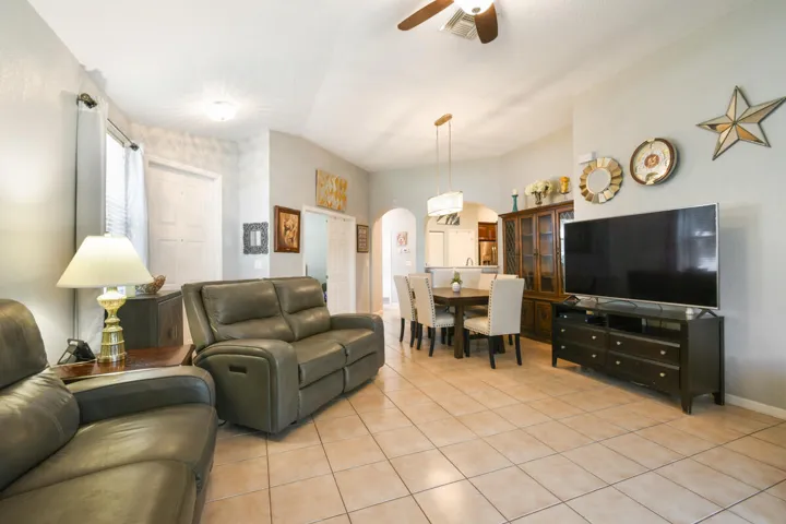 Open-concept living area featuring tile flooring, neutral wall tones, and recessed lighting