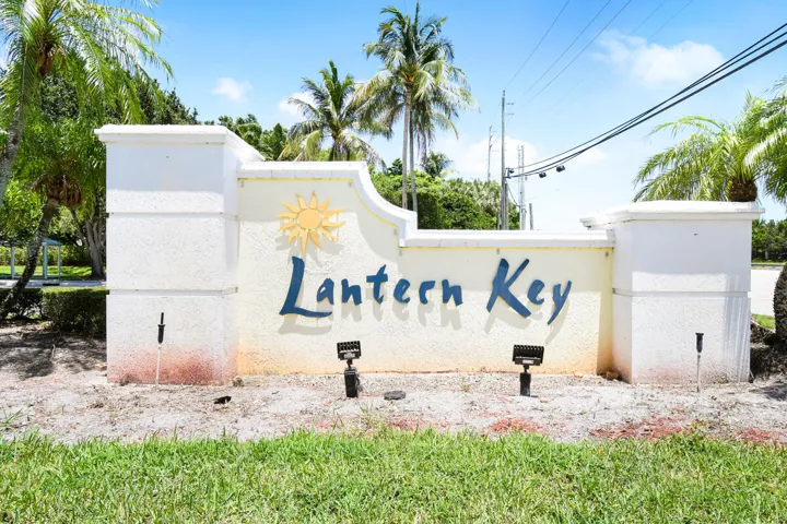 Community entrance sign featuring stucco finish, raised lettering, and an embossed sun motif
