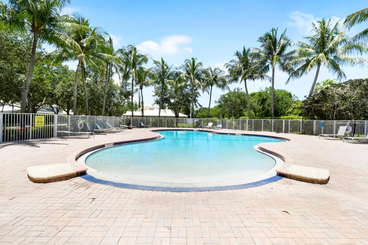 Freeform swimming pool surrounded by a paver deck