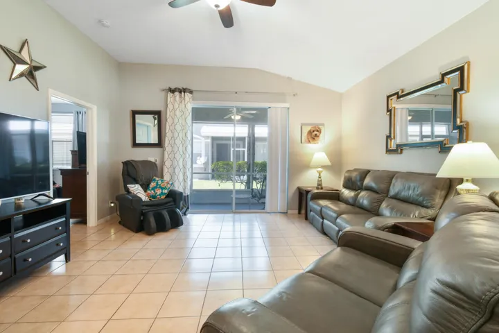 Living area featuring vaulted ceilings, ceiling fan, and tile flooring