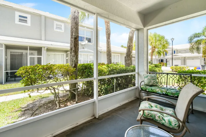 Screened porch with concrete flooring and white framed screens