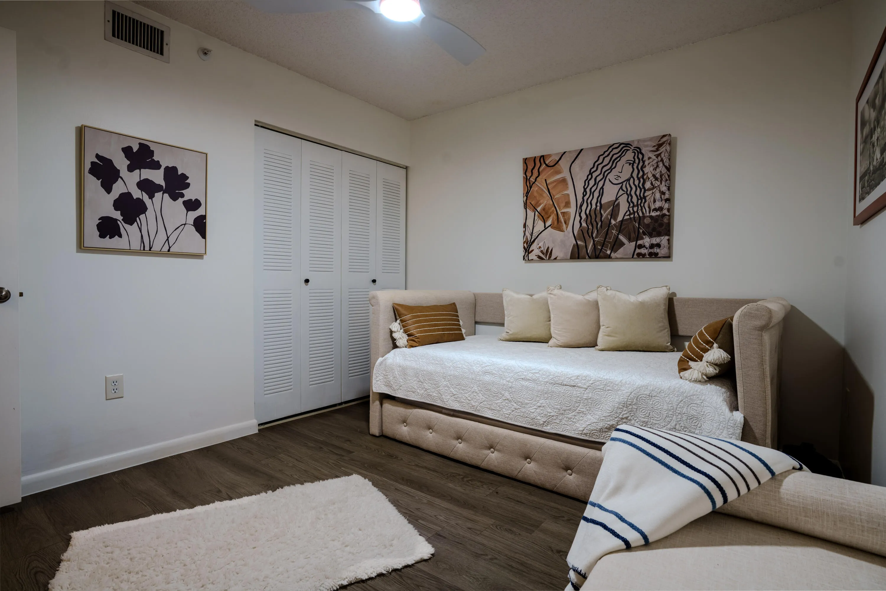 Spacious guest room with ceiling fan.