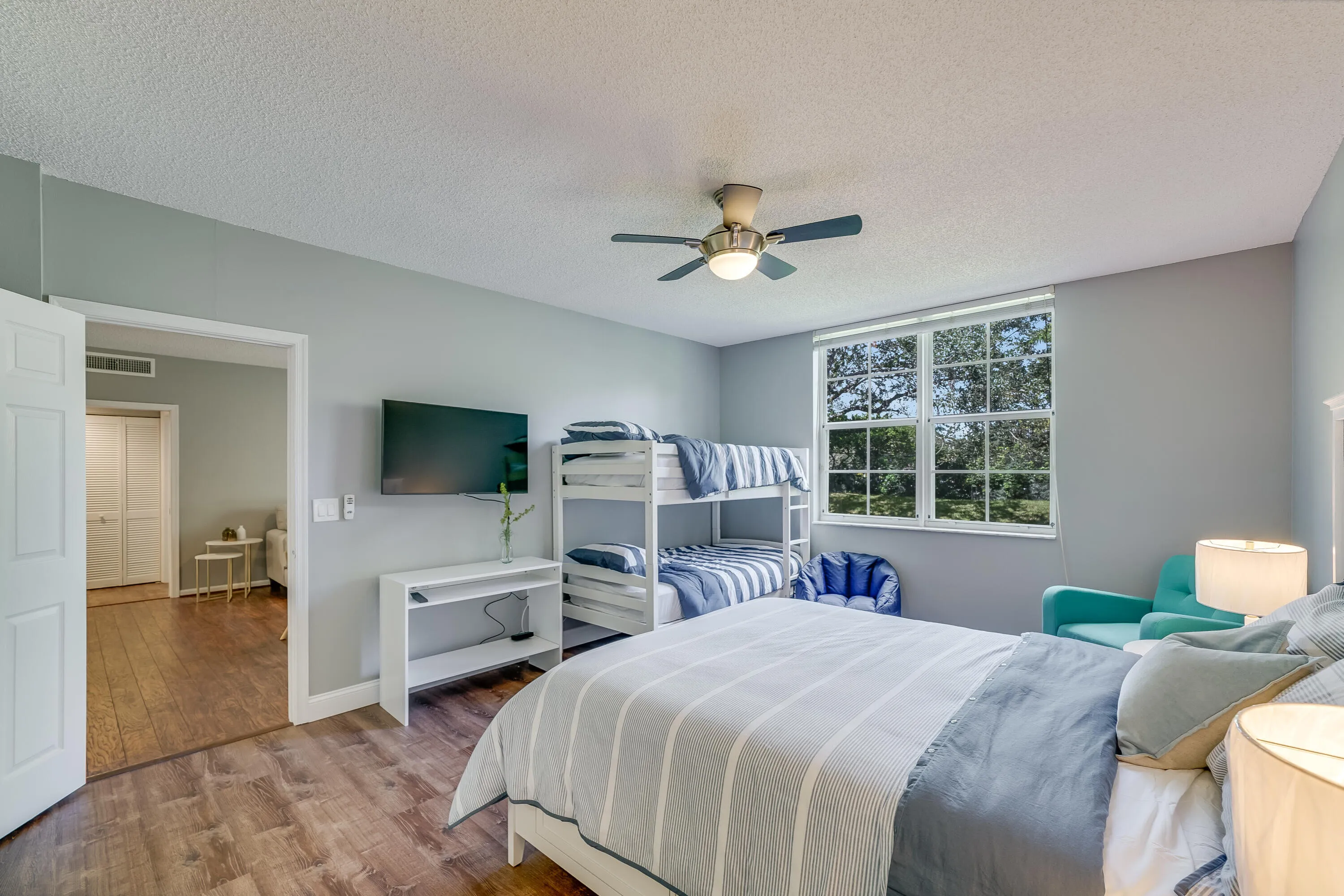 Windowed room featuring wood-finish flooring, light gray walls, and a ceiling fan with integrated lighting