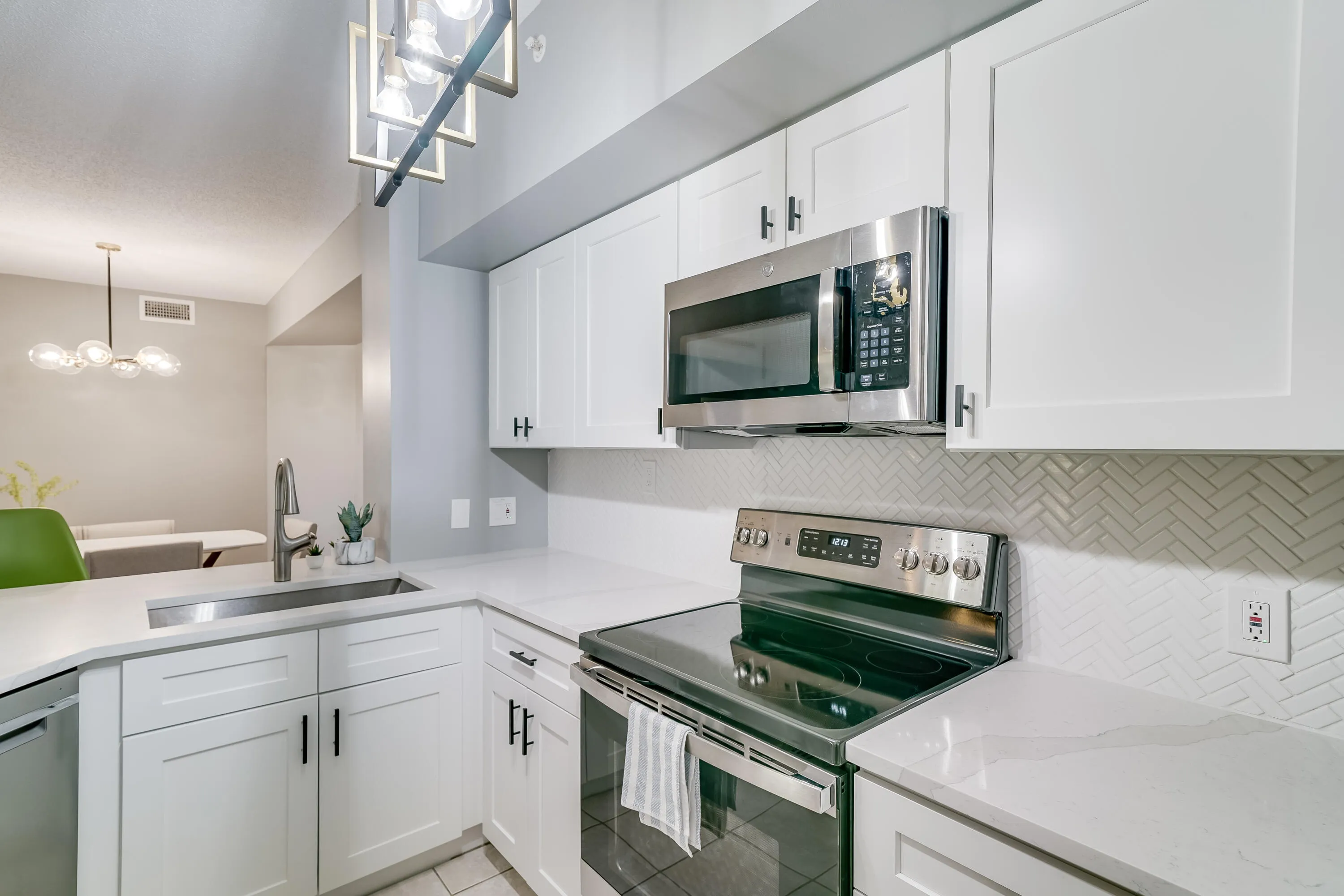 Modern kitchen featuring white shaker cabinetry and stainless steel appliances
