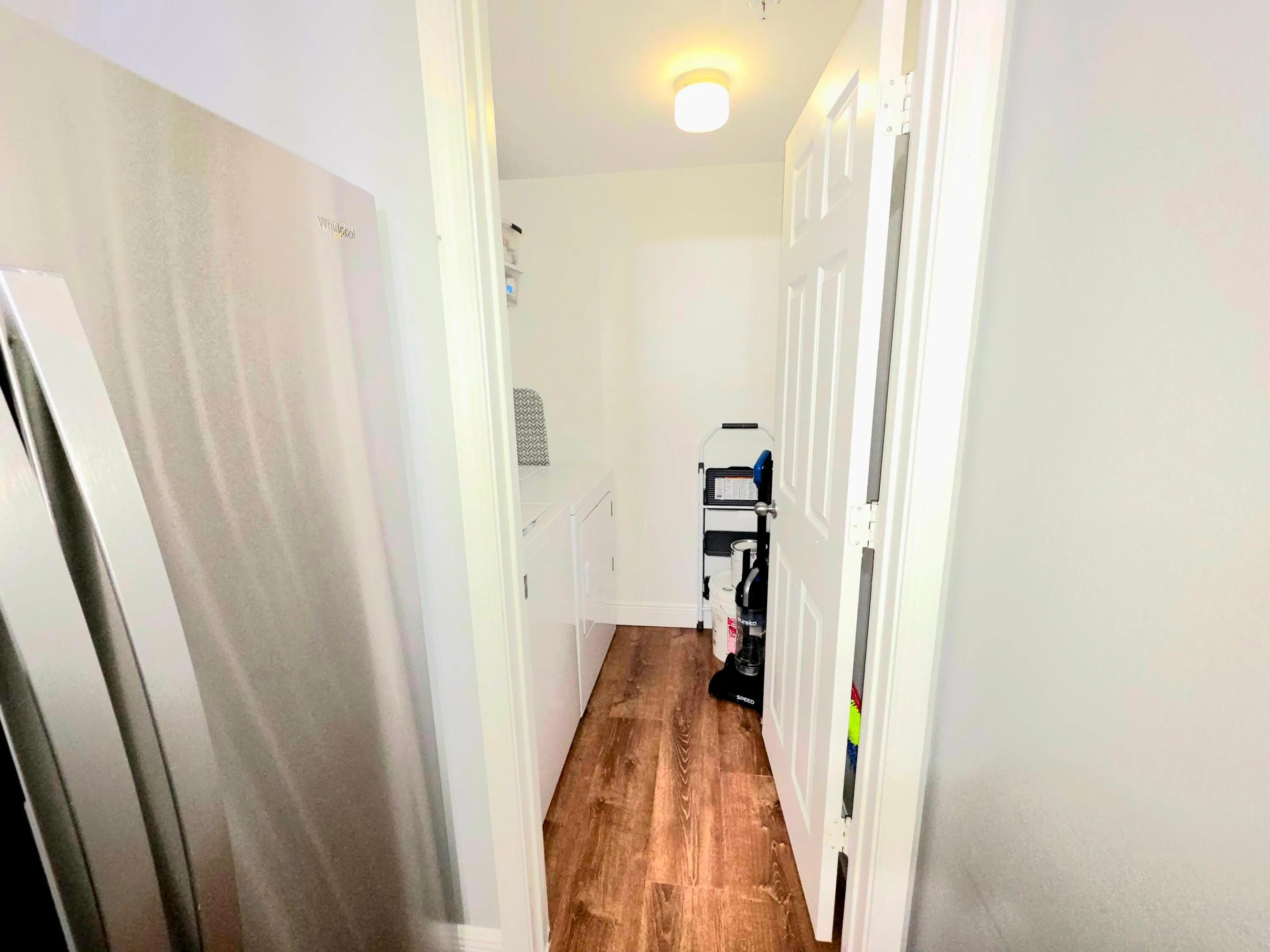 Dedicated laundry area featuring a washer and dryer, integrated wire shelving, and overhead storage