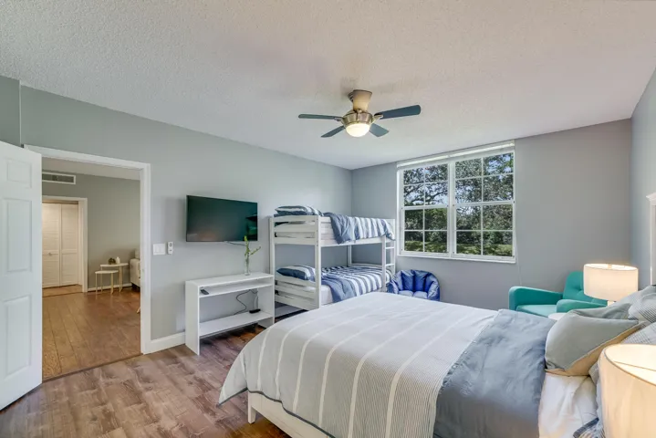 Windowed room featuring wood-finish flooring, light gray walls, and a ceiling fan with integrated lighting