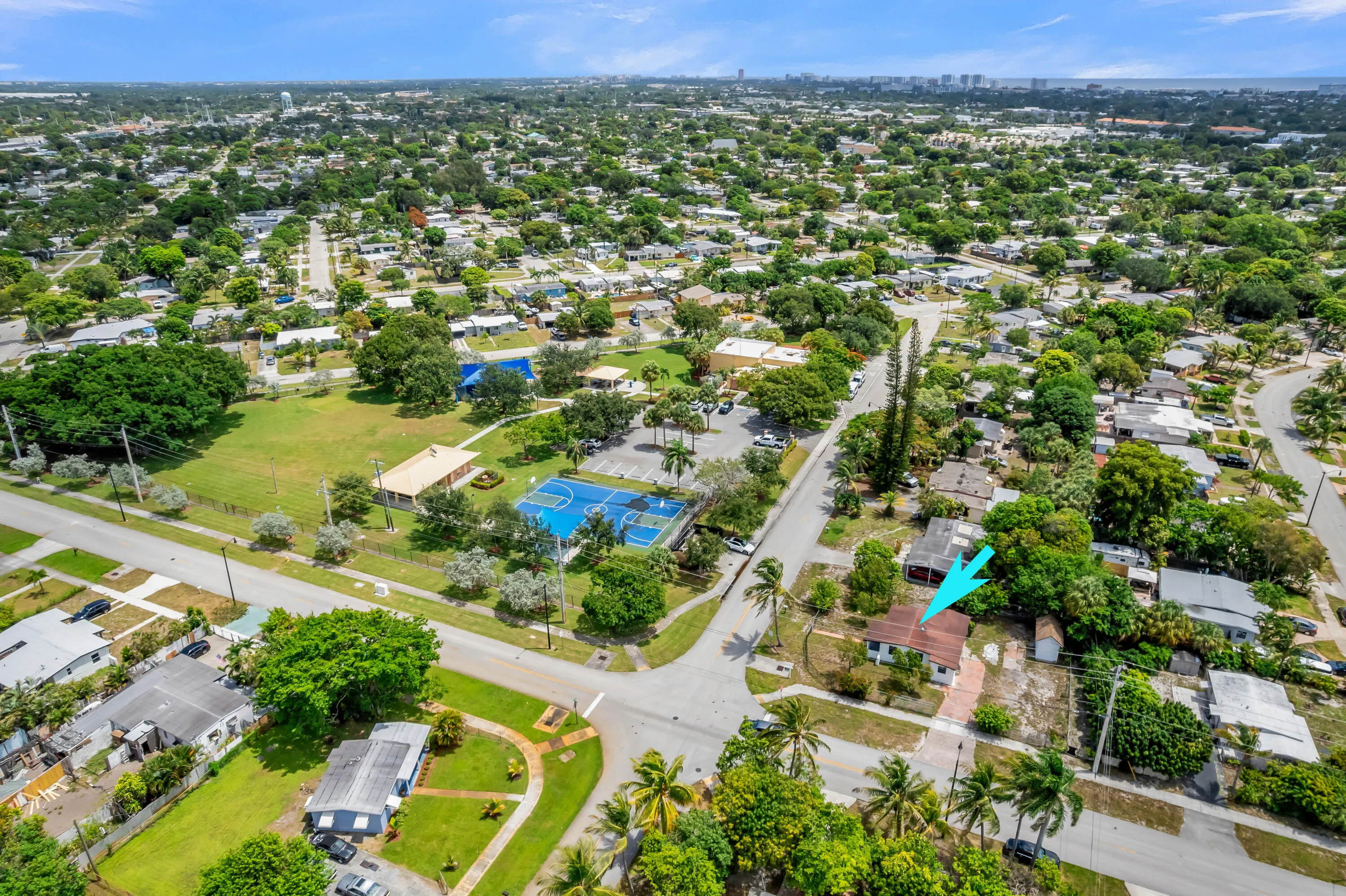 Residential property with a red tile roof and mature landscaping, situated on a corner lot