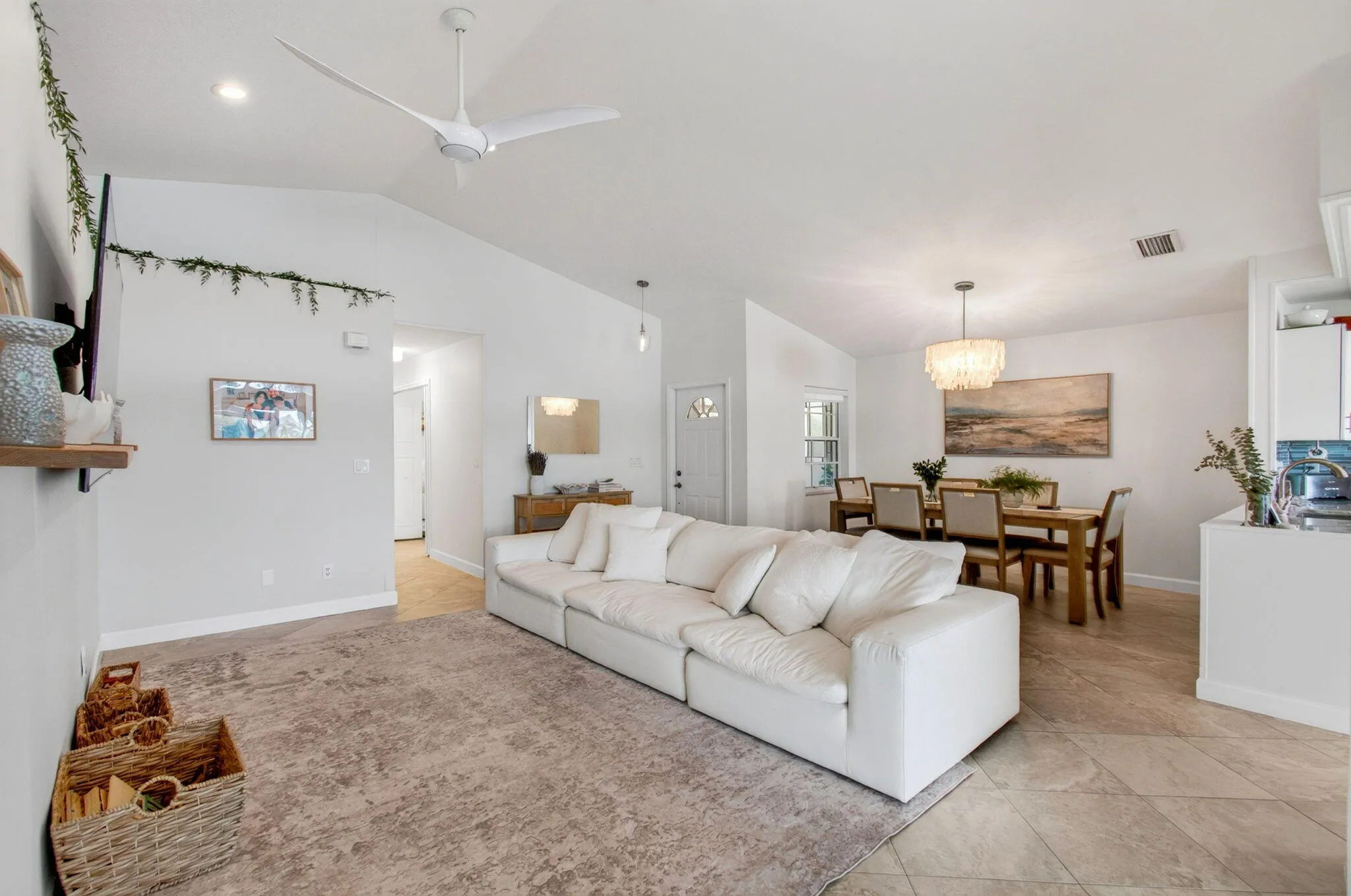 Vaulted ceilings define this open-concept living space, featuring recessed lighting and a modern ceiling fan
