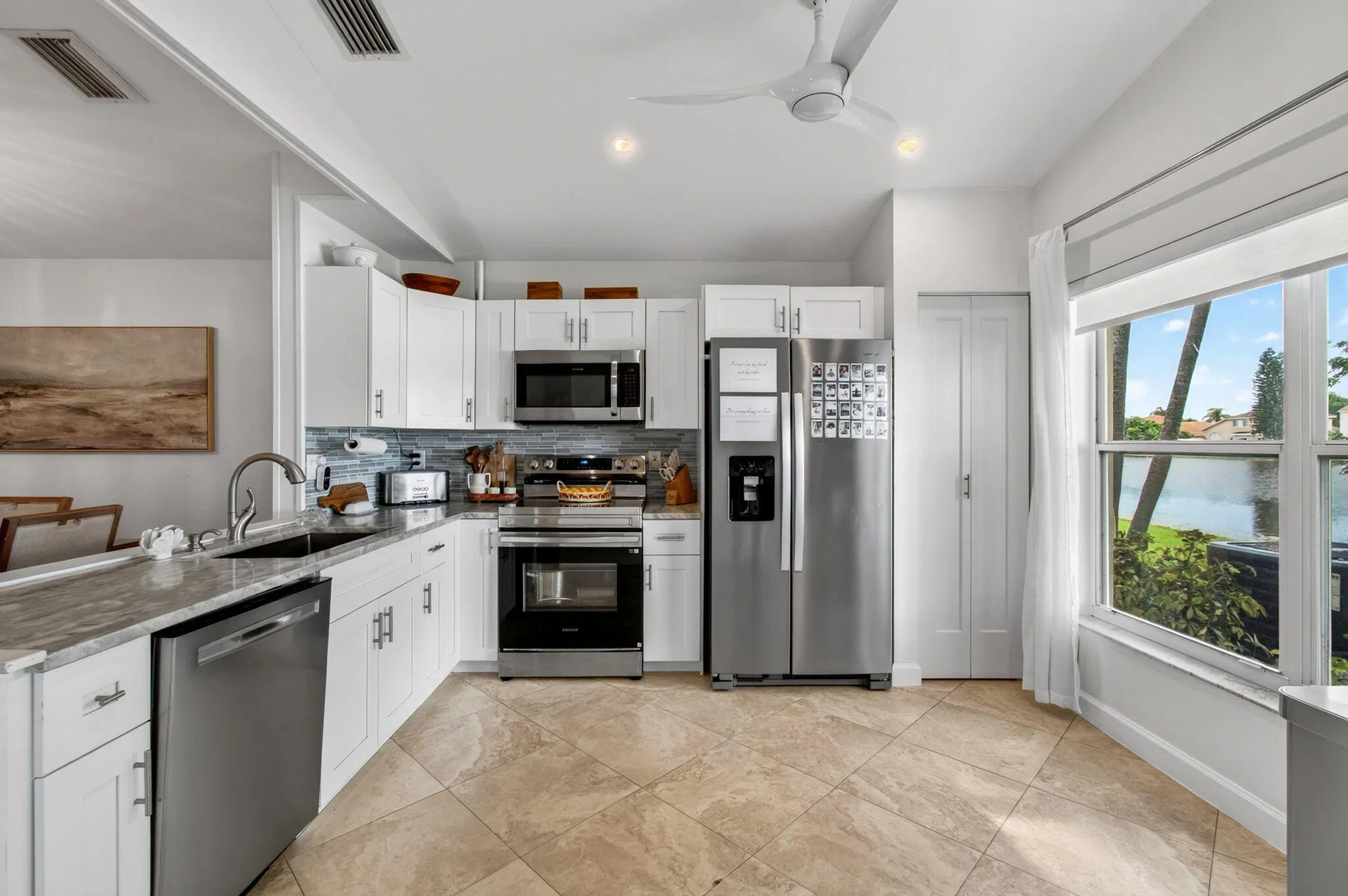 Modern kitchen featuring white cabinetry, stainless steel appliances, and a tiled backsplash