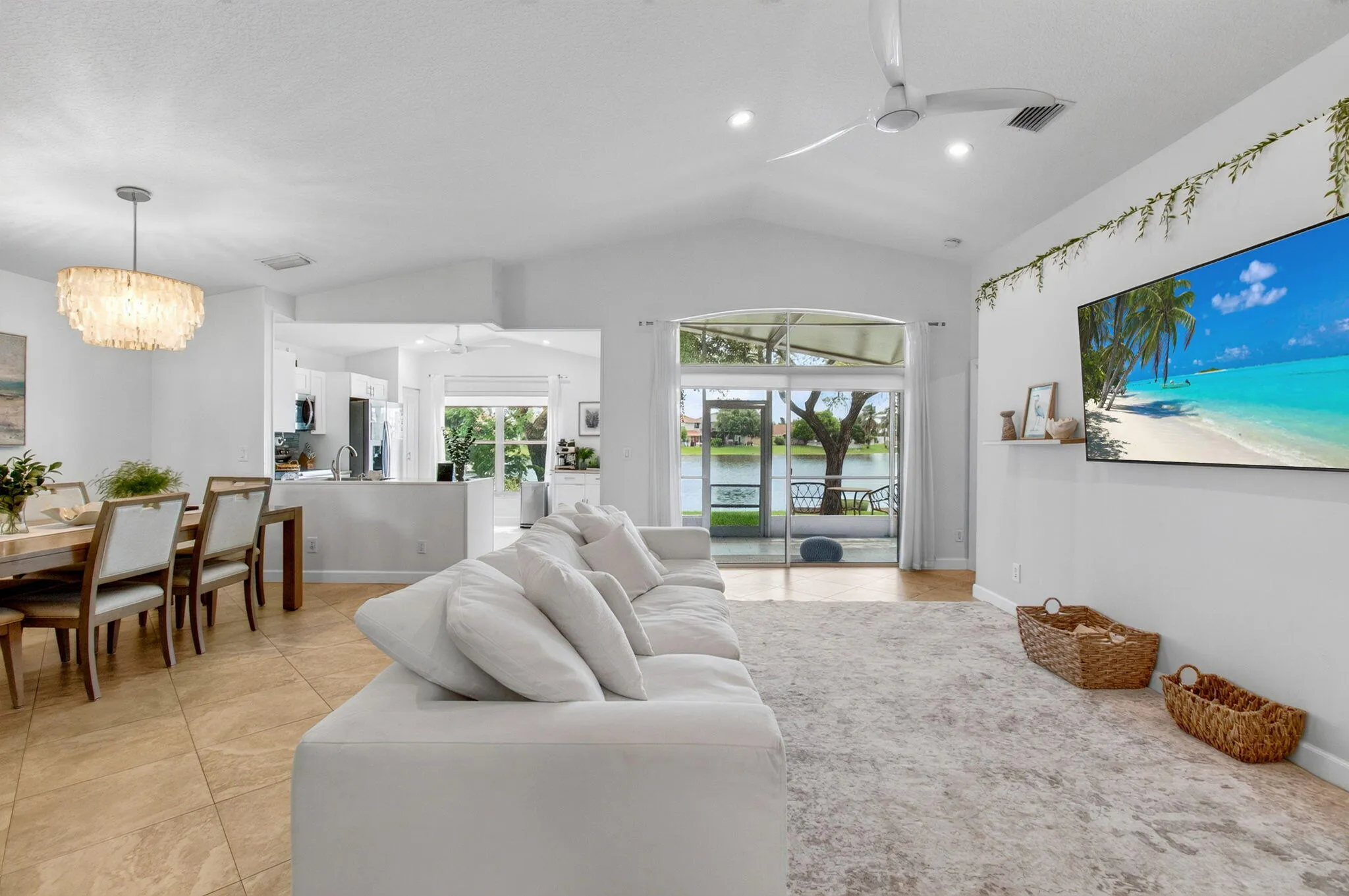 Living area featuring vaulted ceilings, recessed lighting, and large tile flooring