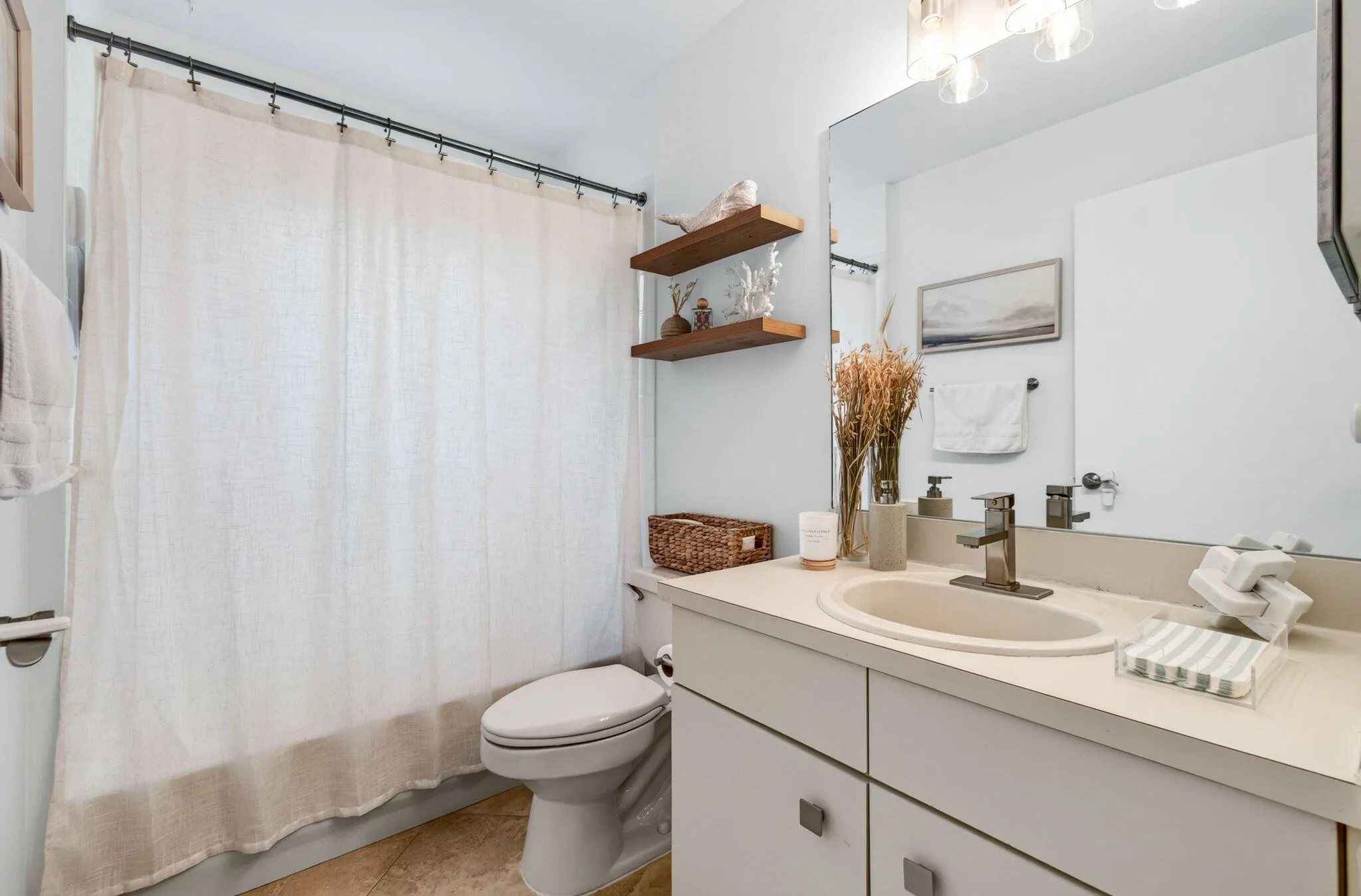 Bathroom featuring a single vanity with an integrated sink, brushed nickel faucet, and a large wall-mounted mirror