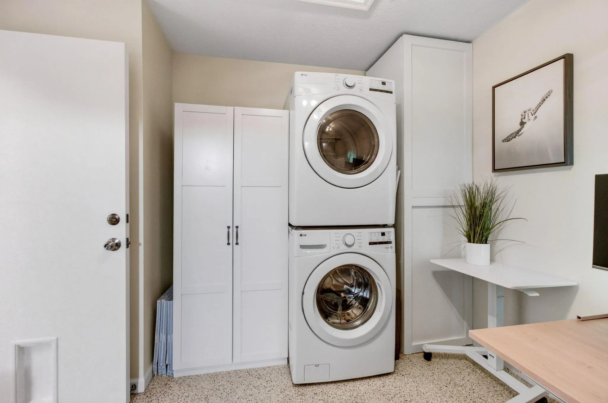 Dedicated laundry area featuring stacked front-load washer and dryer units