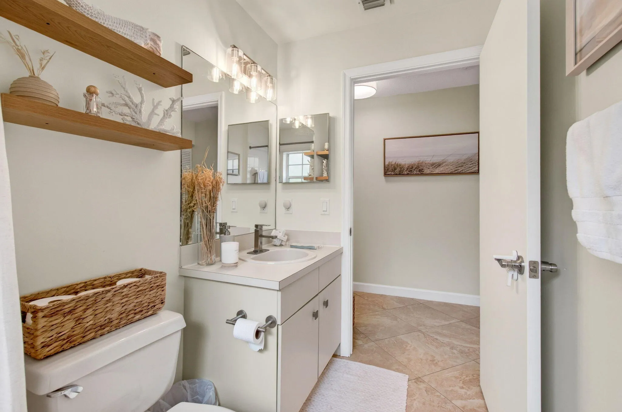 Bathroom vanity with a single basin sink, wall-mounted mirror, and overhead light fixture