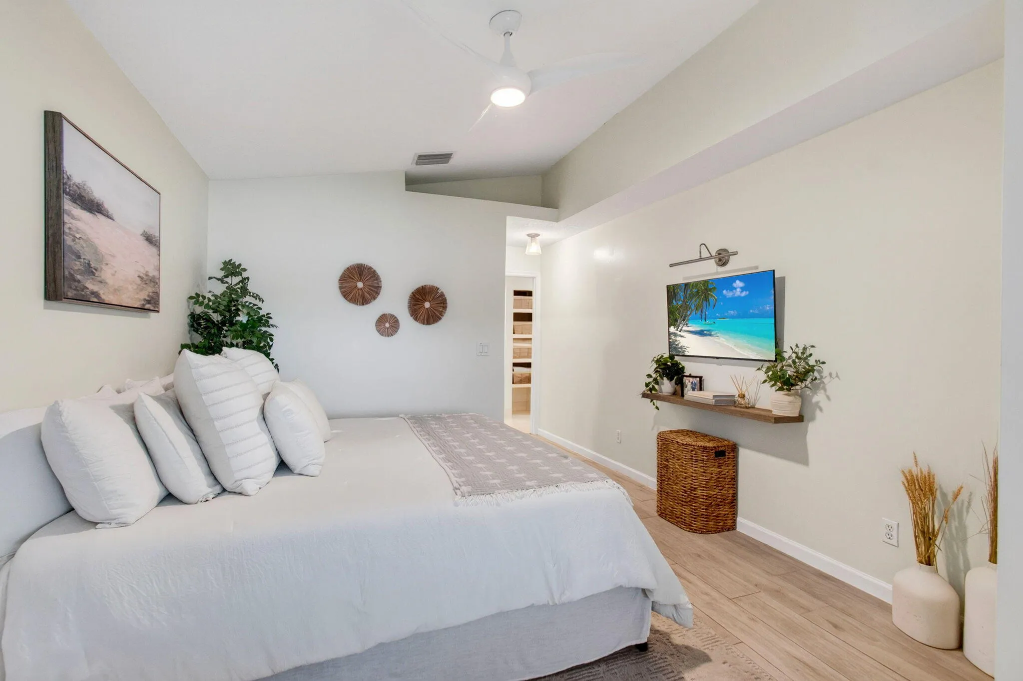 Spacious bedroom featuring wood-finish flooring, a contemporary ceiling fan, and recessed lighting