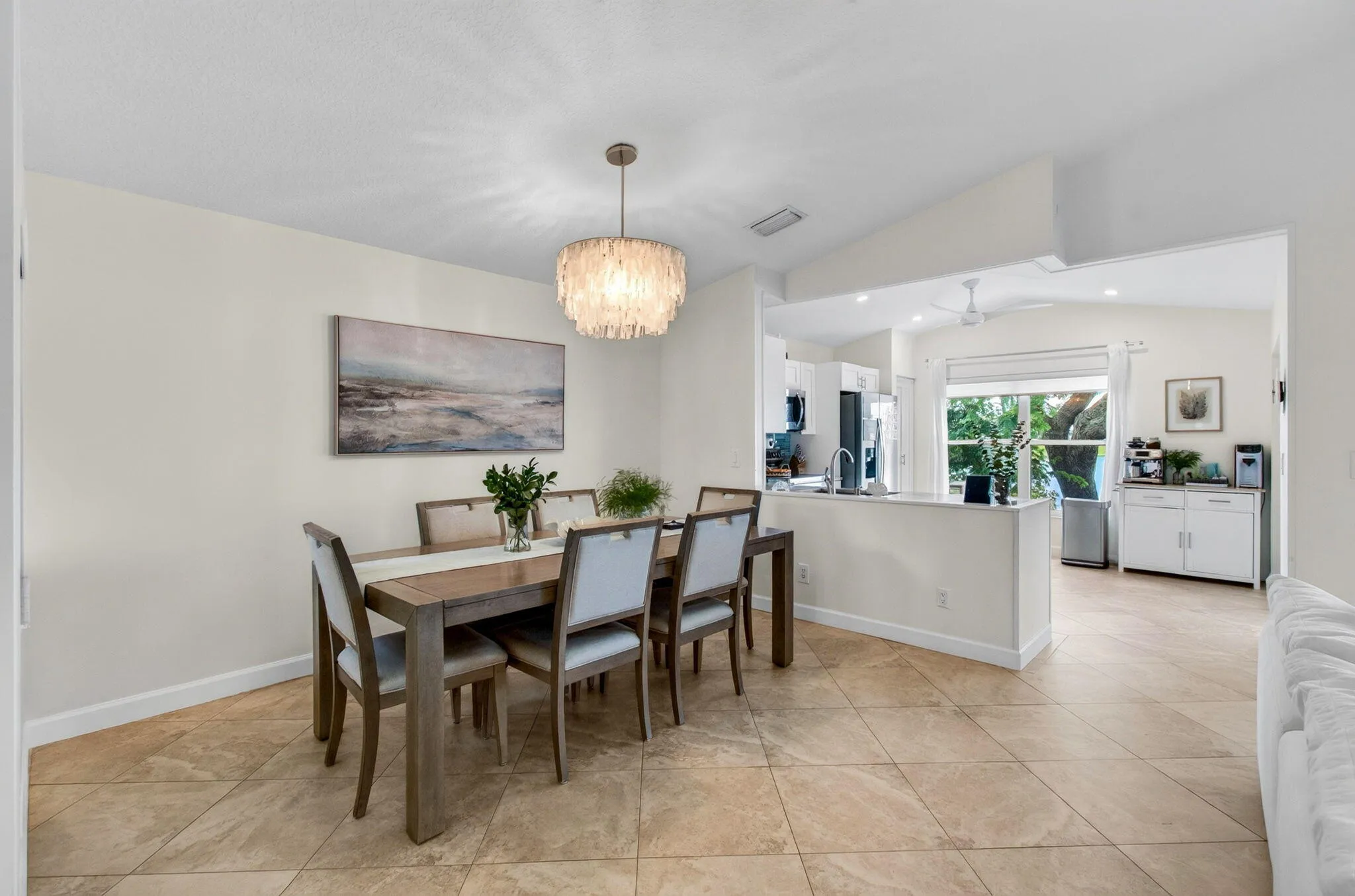 Dining area featuring a contemporary chandelier and large tile flooring