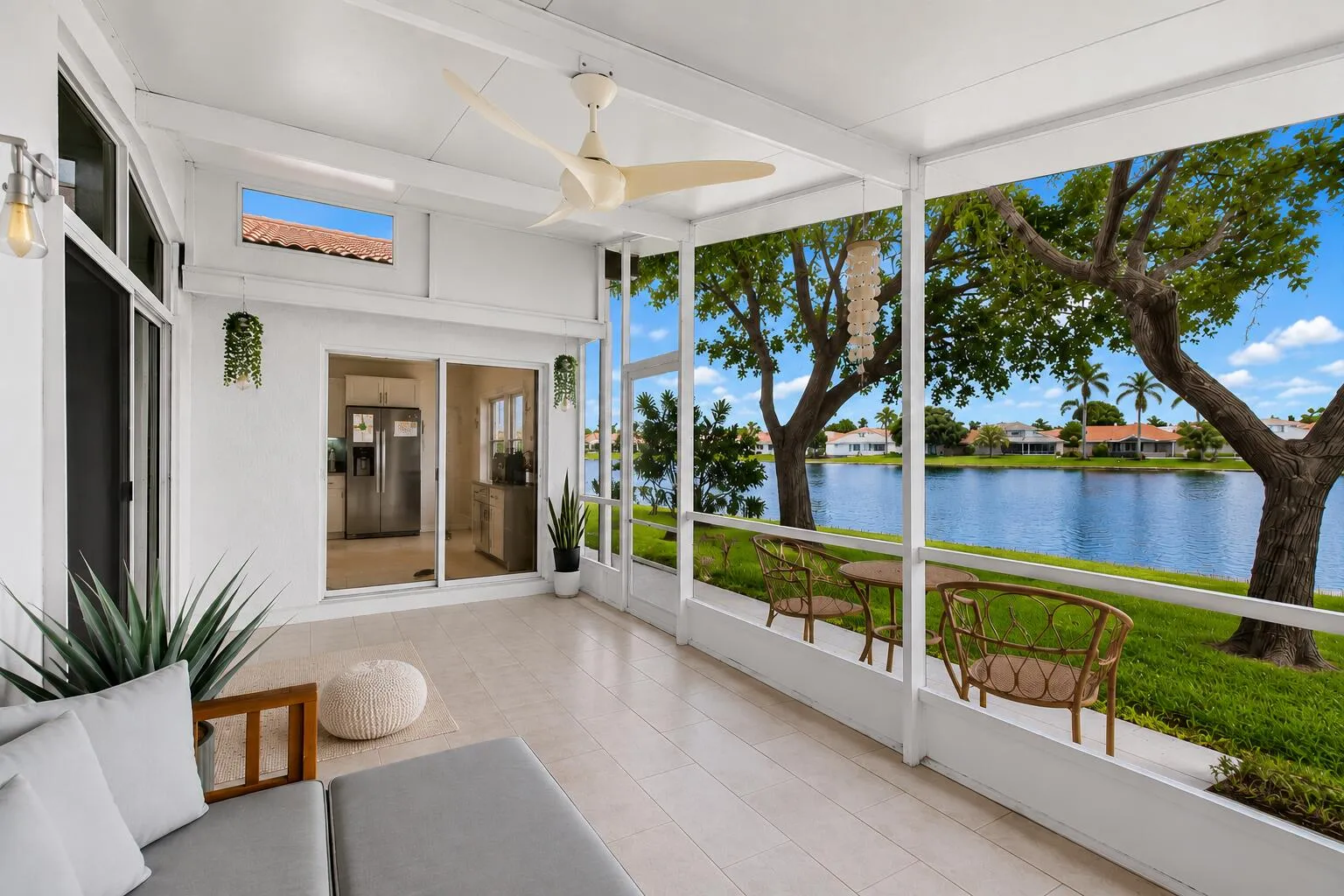 Screened patio featuring light-toned tile flooring, a ceiling fan, and sliding glass door access