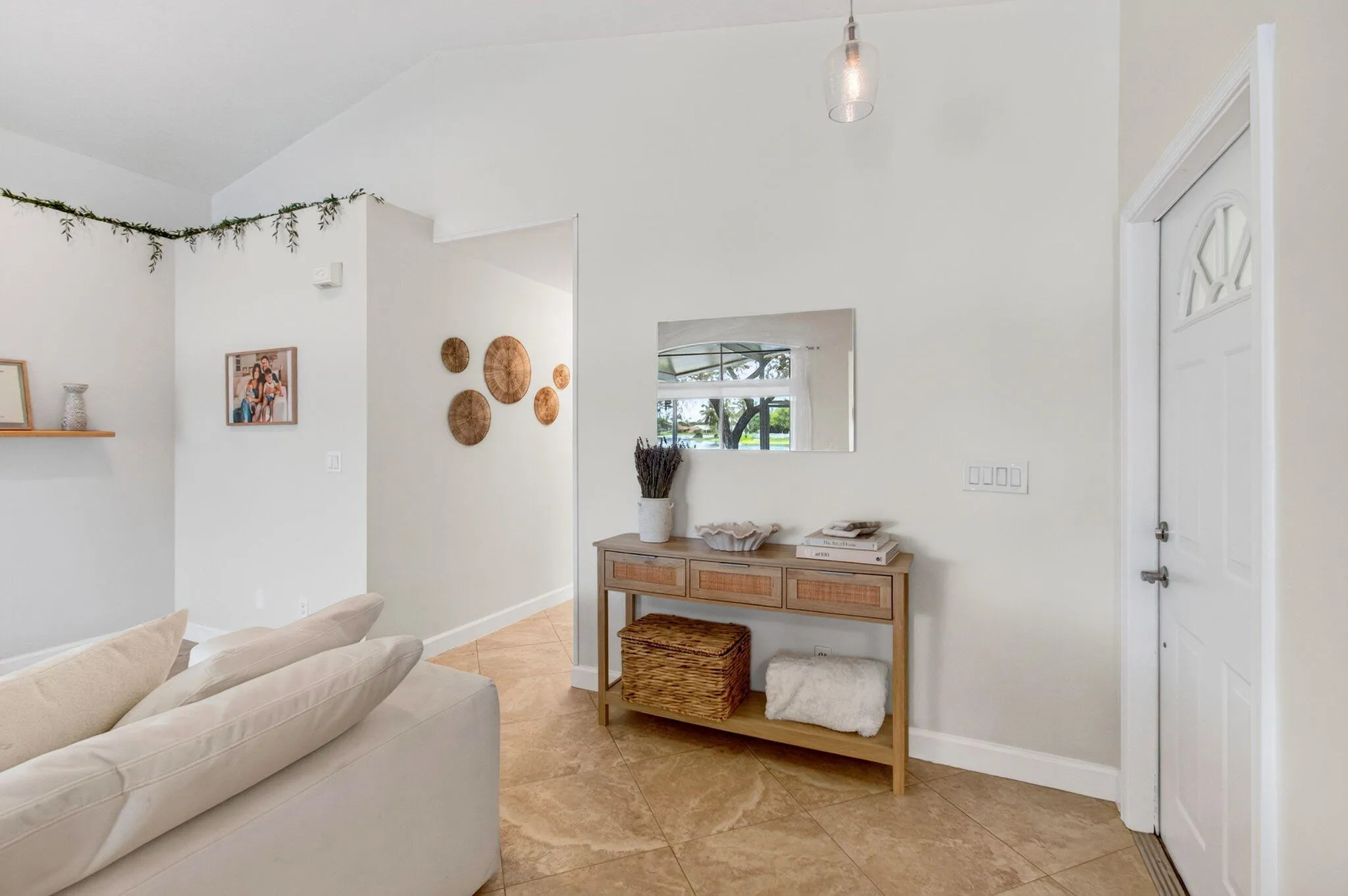 Entryway featuring a white paneled door with decorative glass, a recessed mirror, and a clear glass pendant light fixture