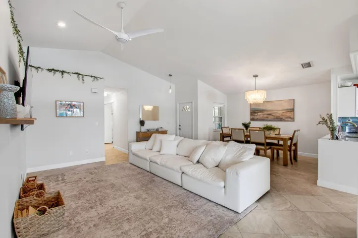 Vaulted ceilings define this open-concept living space, featuring recessed lighting and a modern ceiling fan
