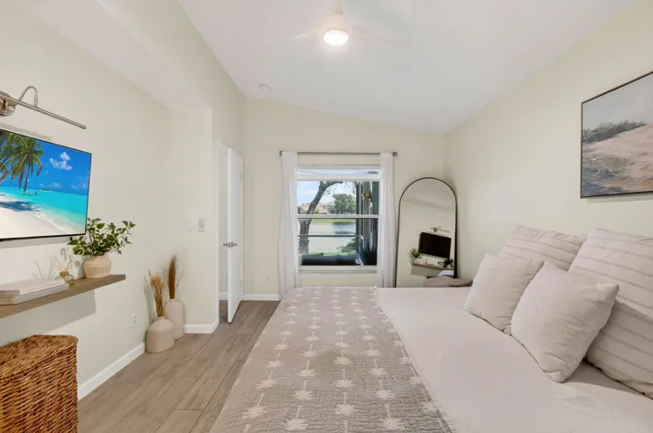 Room featuring vaulted ceilings, wood-finish flooring, and a window with a water feature​​‌​​​​‌​​‌‌​‌‌​​​‌‌​‌​‌​‌​​​‌​​ backdrop