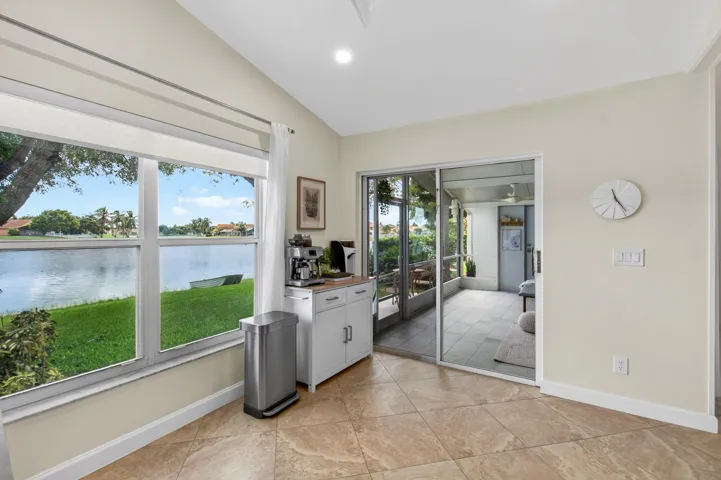 Spacious room featuring vaulted ceilings, a ceiling fan with integrated lighting, plank-style flooring, and light-toned walls