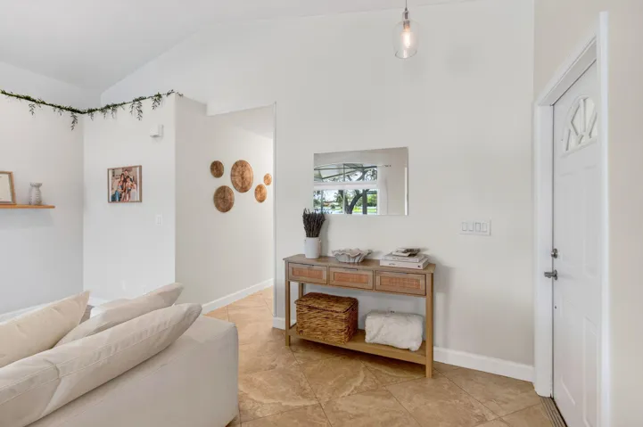 Entryway featuring a white paneled door with decorative glass, a recessed mirror, and a clear glass pendant light fixture