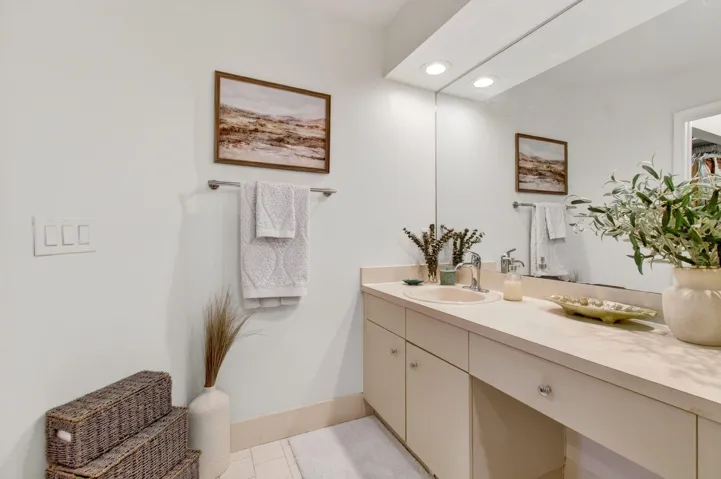 Bathroom vanity featuring an integrated sink, polished chrome faucet, and ample countertop space