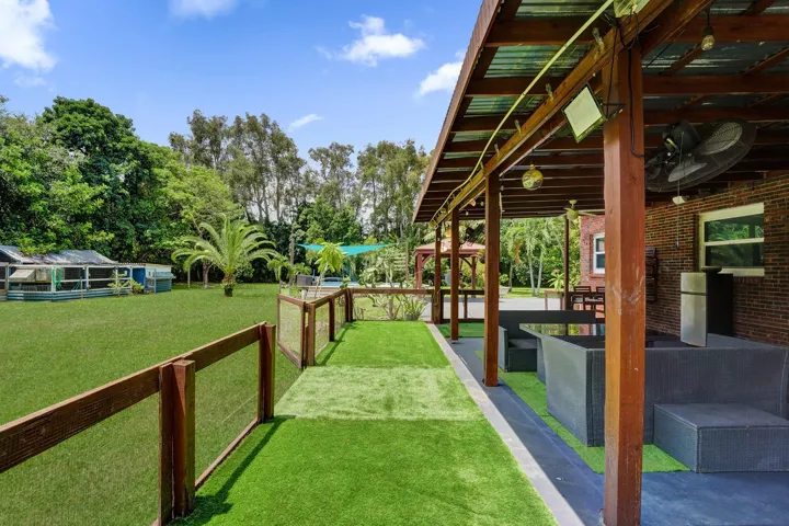 Covered side patio with convenient additional fenced area- perfect for kids and pets!!
