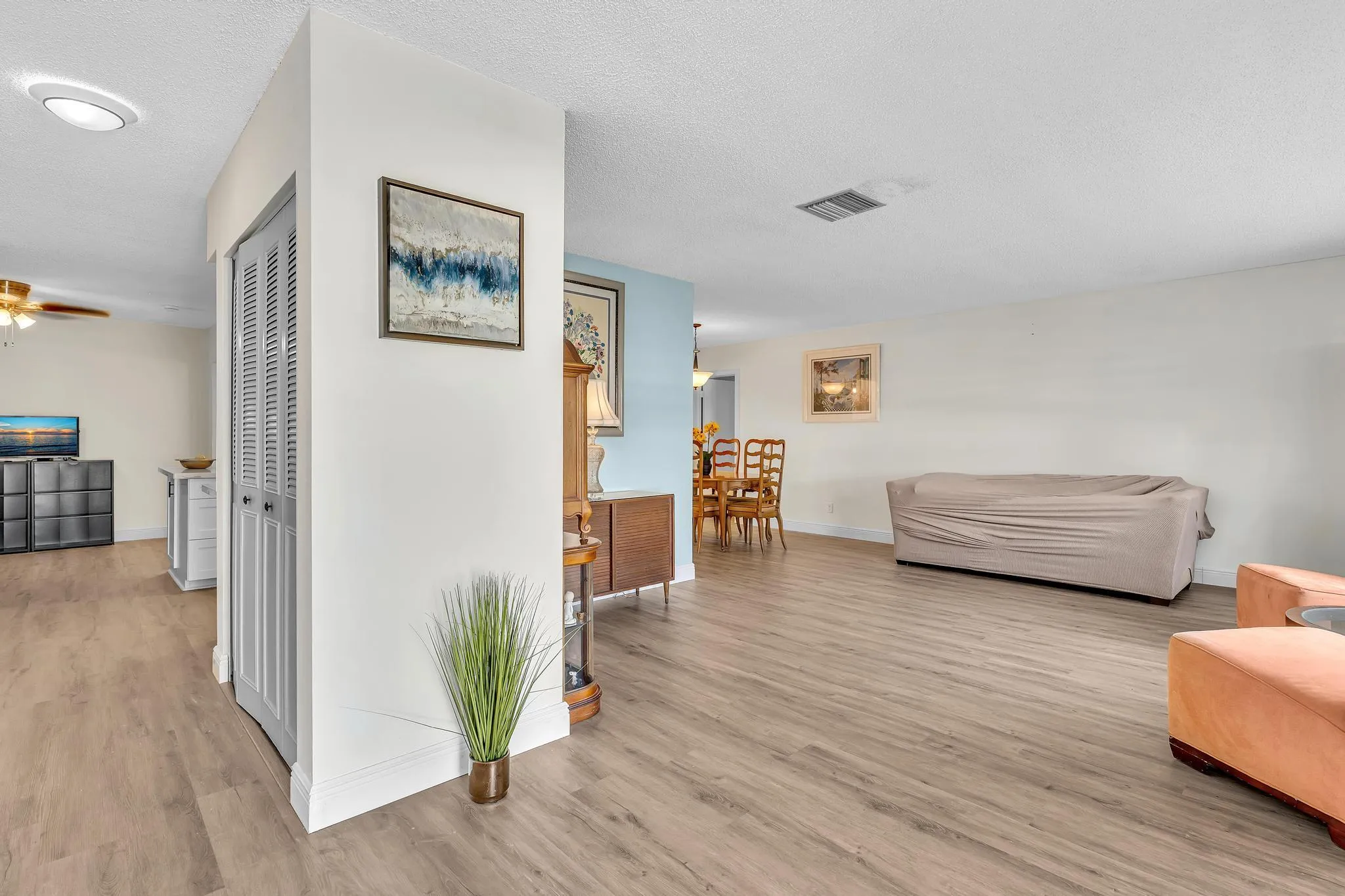 Open-concept interior featuring light wood-finish flooring, white walls, and recessed lighting