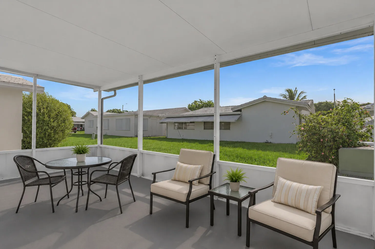 Screened lanai featuring a grey floor, white framed screens, and a solid white ceiling