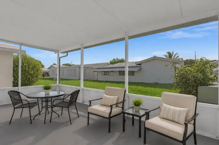 Screened lanai featuring a grey floor, white framed screens, and a solid white ceiling