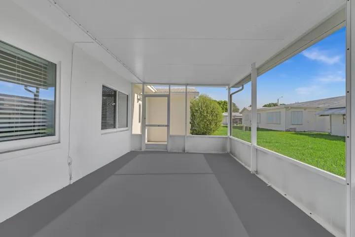Screened patio with a painted concrete floor, white exterior walls, and multiple windows with​​‌​​​​‌​​‌‌​‌‌​​​‌‌​‌​‌​‌​​​‌​​ blinds