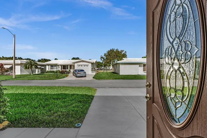 Entryway featuring a decorative leaded glass door and wood-finish frame, opening to a view of the street