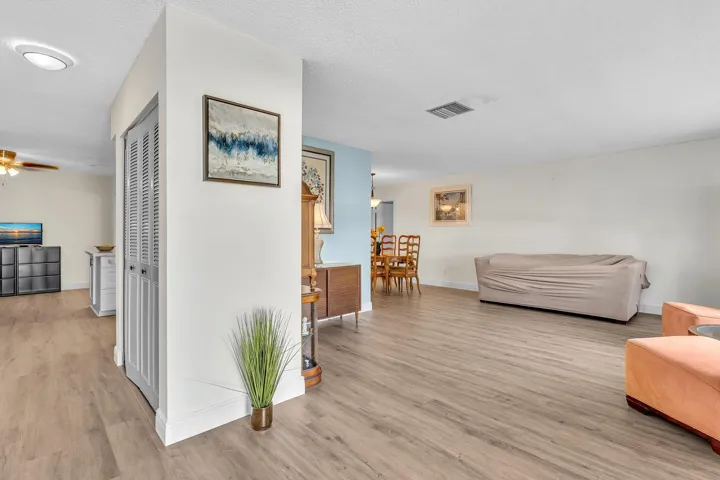 Open-concept interior featuring light wood-finish flooring, white walls, and recessed lighting