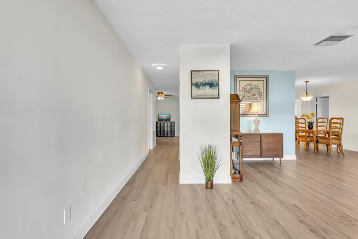 Expansive open-concept living area featuring wood-finish flooring, recessed lighting, and a neutral color palette