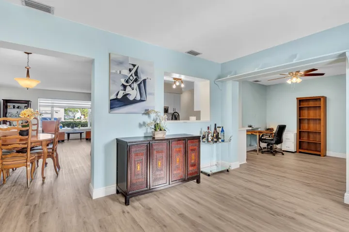 Open-concept interior featuring wood-finish flooring, light blue wall paint, and white trim throughout