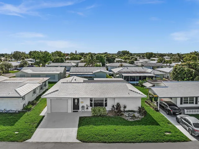 White exterior residence featuring a tiled roof, an attached single-car garage, and a concrete driveway