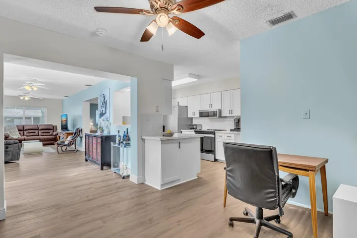 Open-concept living space featuring wood-finish flooring, recessed lighting, and a neutral color palette