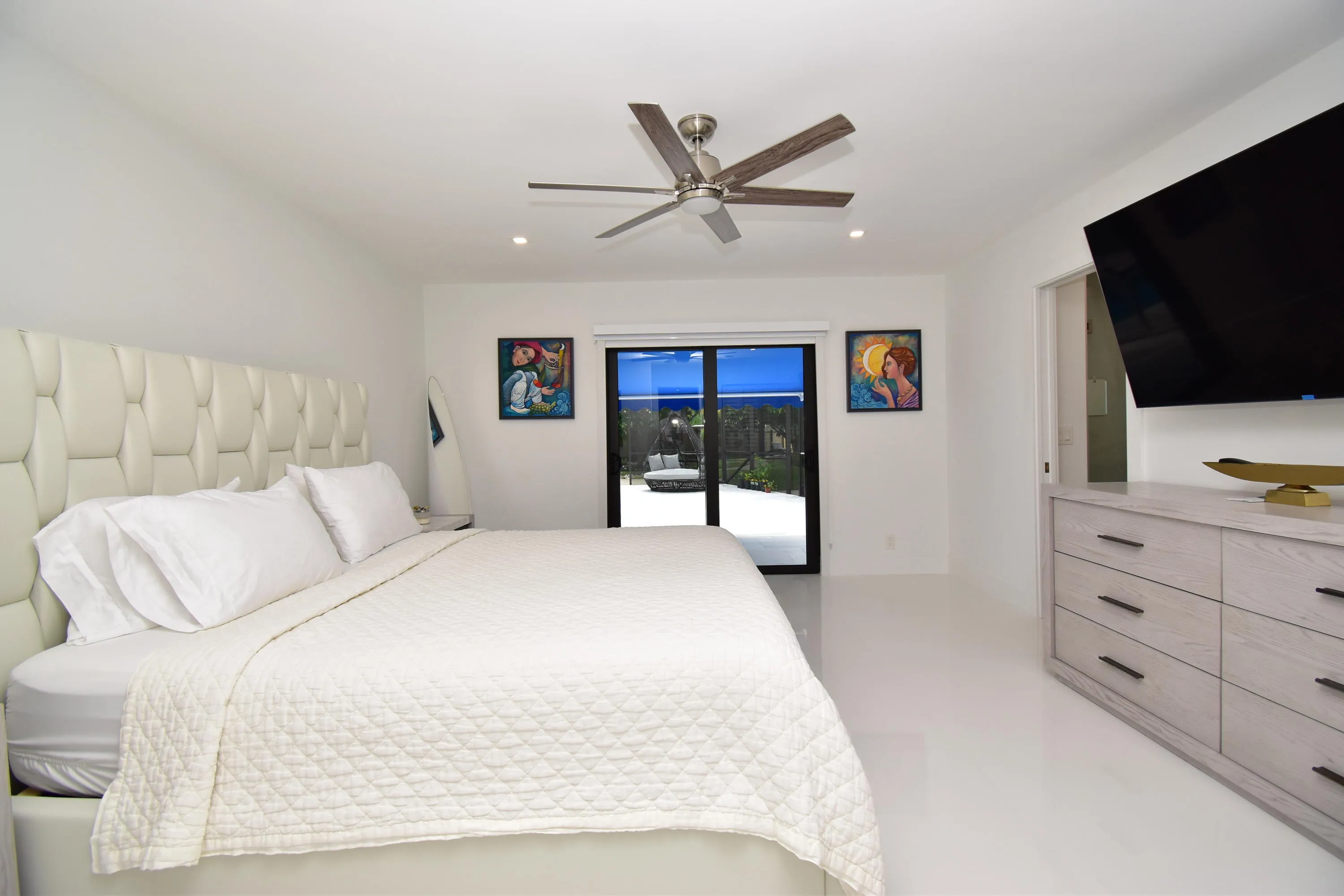 Spacious room featuring light-toned flooring, white walls, and recessed lighting
